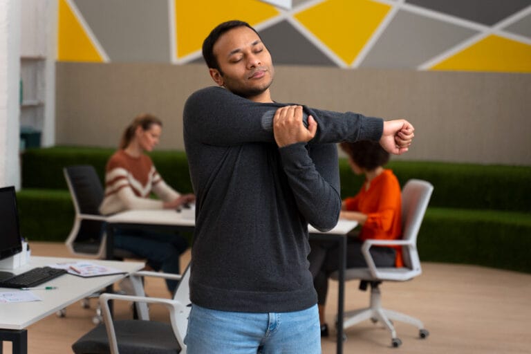 male employee with hypermobility in the workplace carrying out some joint exercise